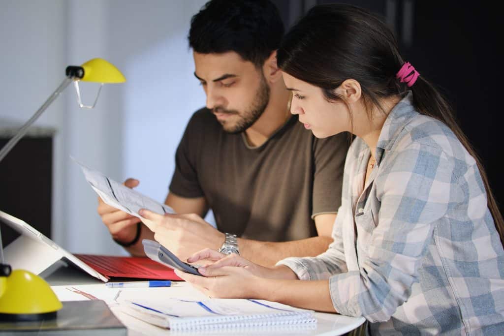Young couple reviewing invoices and doing family business plan. This image refers to investment property tax deductions.